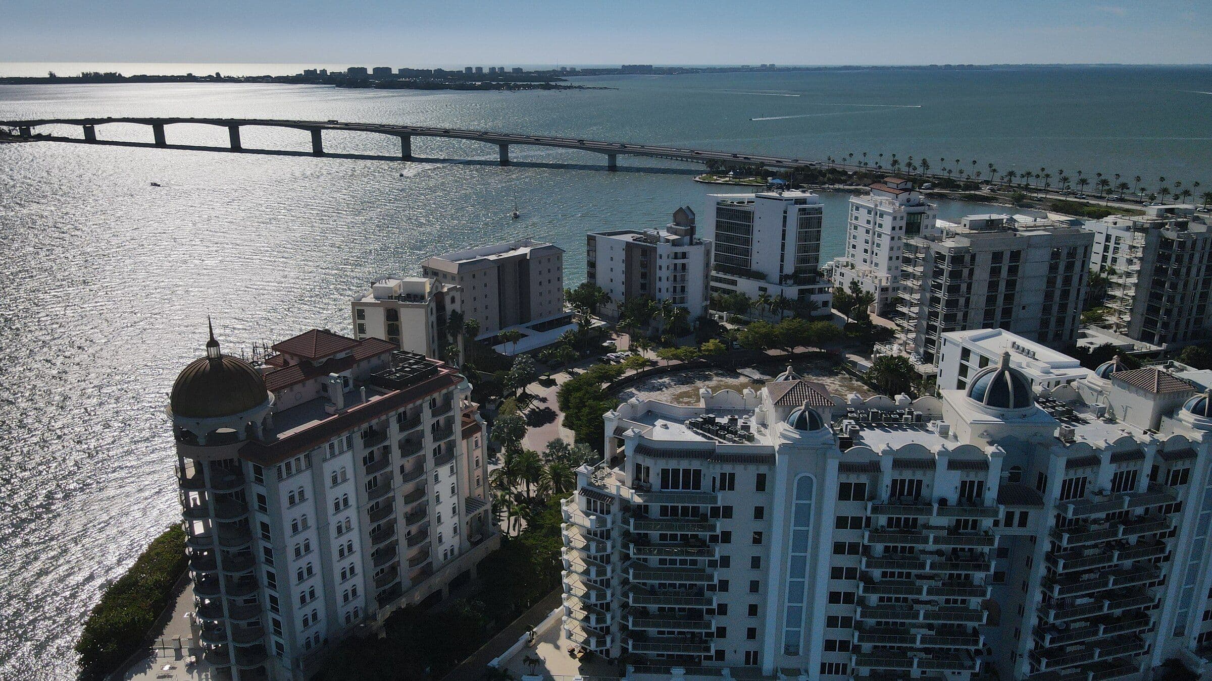 Downtown Sarasota skyline seen across the bay at dusk, mid-rise towers along the waterfront